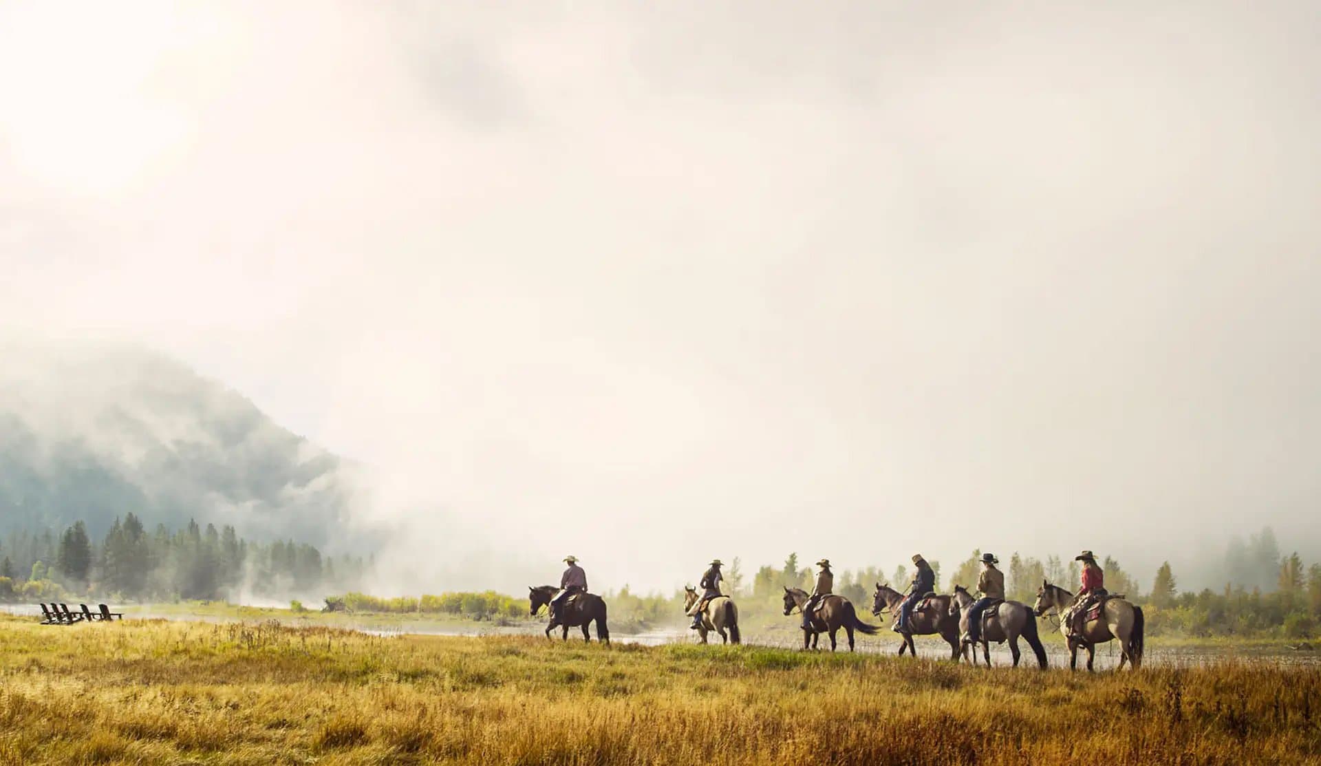 A bunch of people on horses in a field